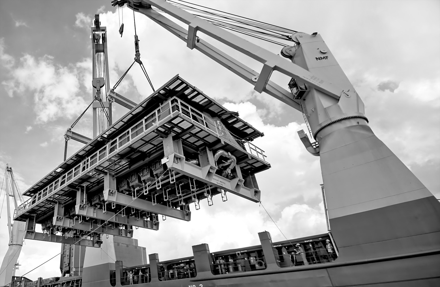 A heavy-lift module being loaded by a ship's crane